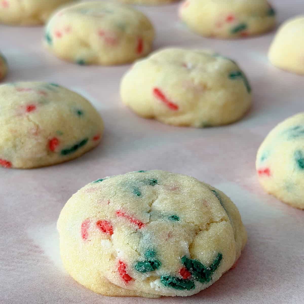Christmas Sugardoodle Cookies on parchment paper with a Christmas plaid backgroun