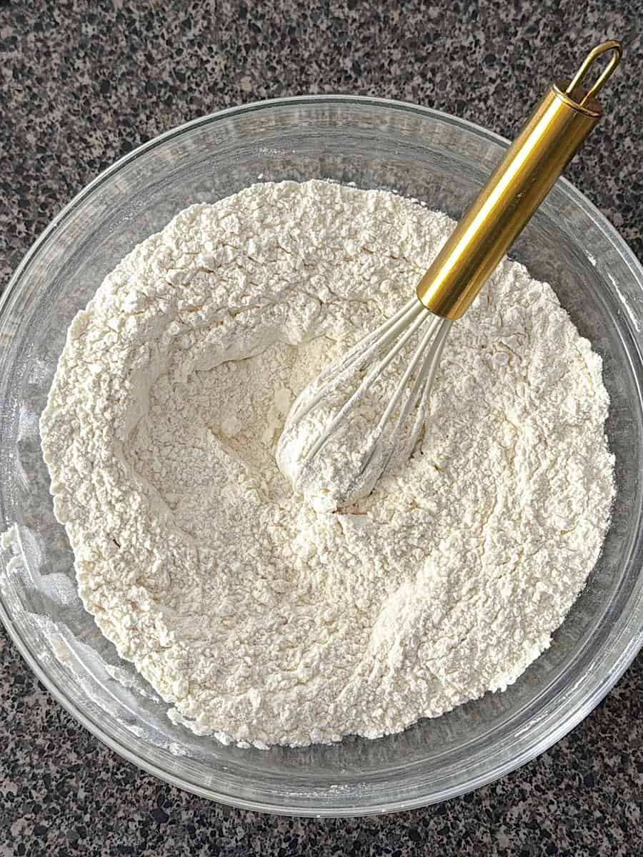 A bowl with flour, salt, and baking powder.