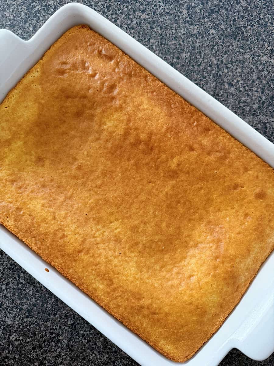 A yellow cake in a white baking dish.