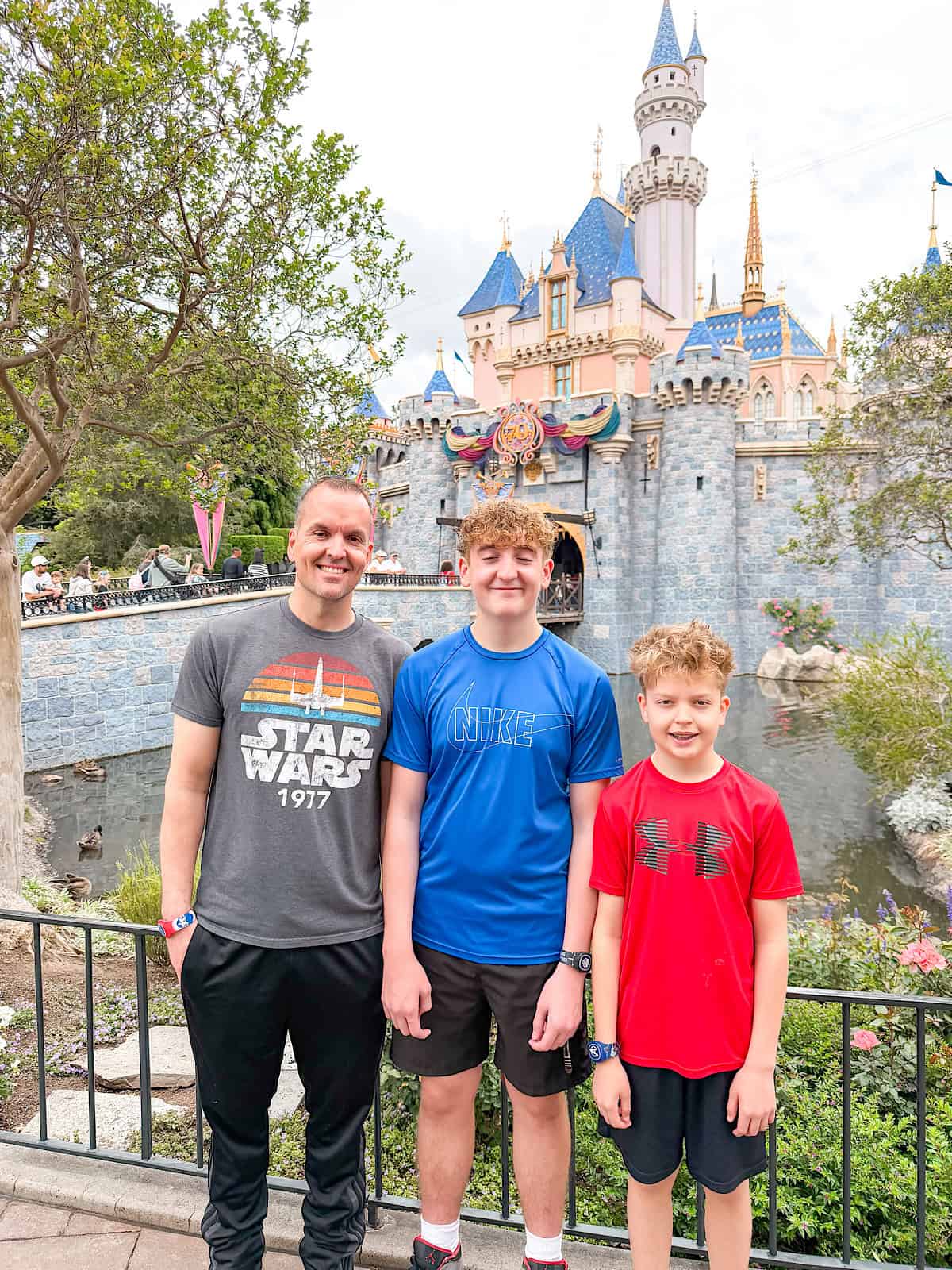 A picture of a family in front of Sleeping Beauty Castle.