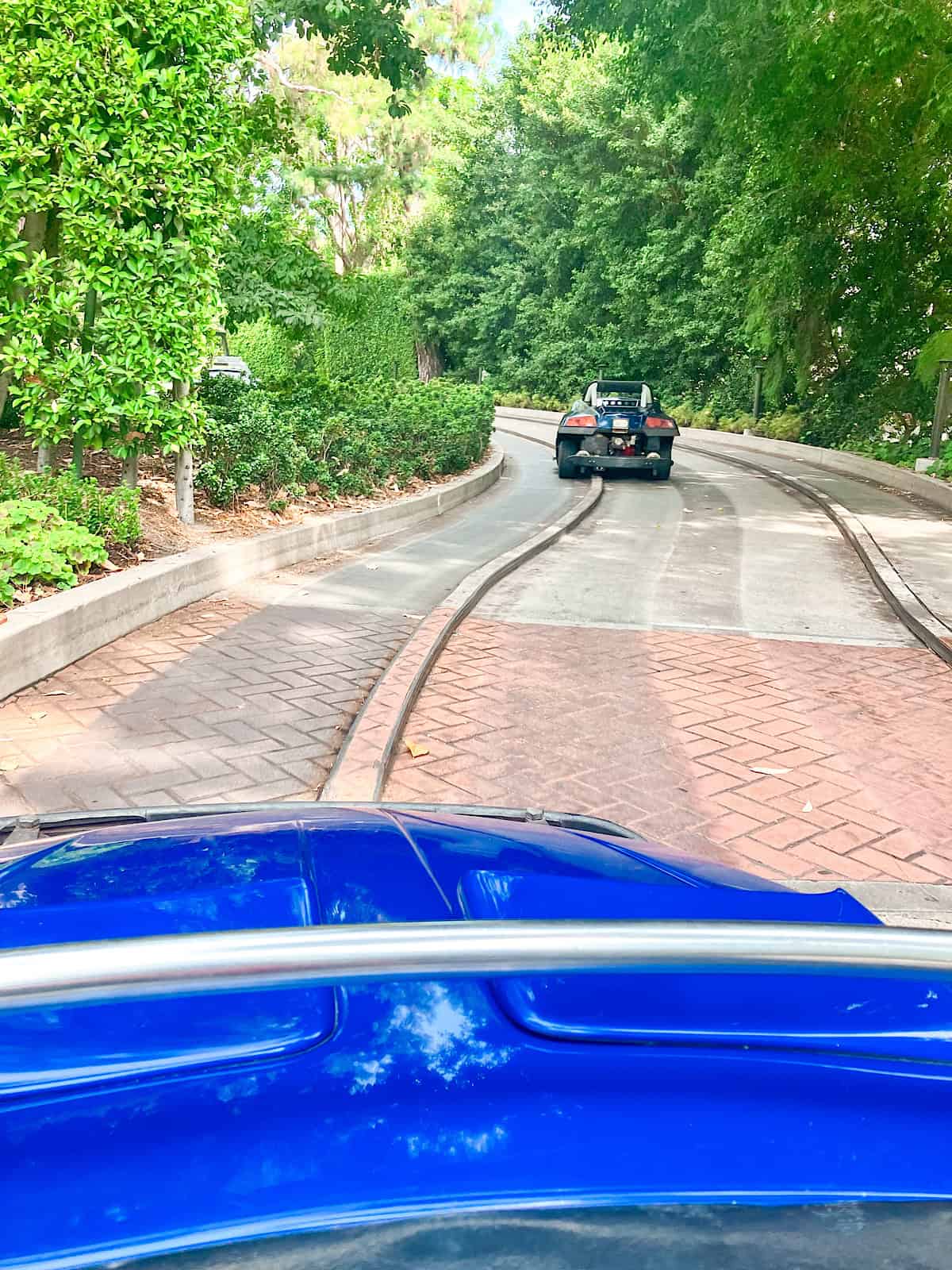 Two cars driving on the Autopia track at Disneyland.