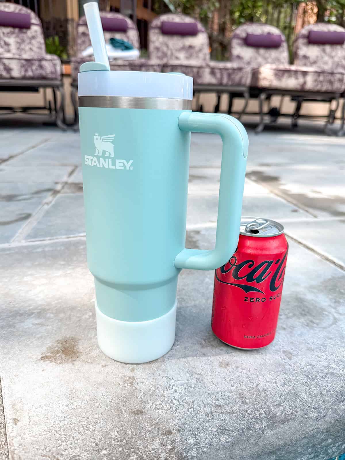 A Stanley cup and a can of coke zero by the hot tub at Disney's Grand Californian Hotel.