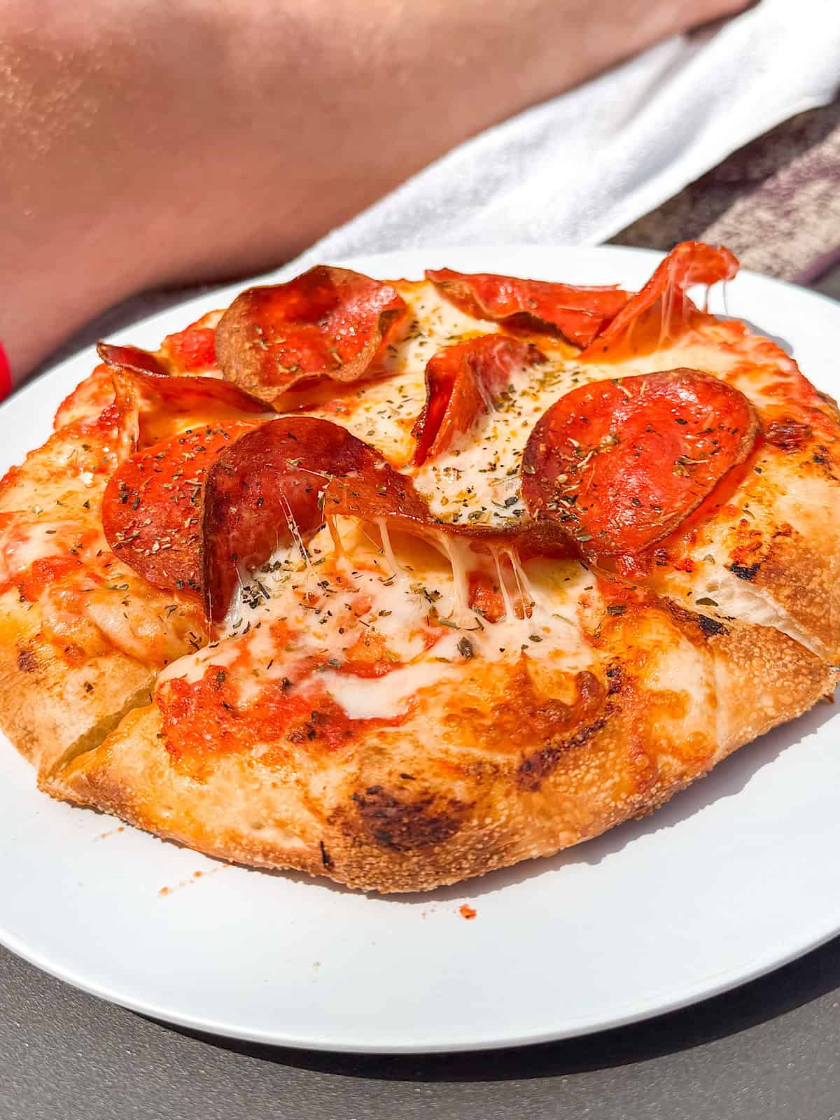 A pepperoni pizza on a white plate.