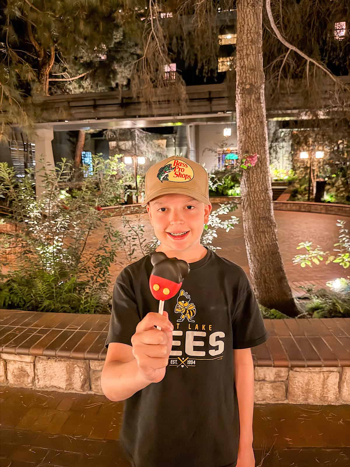 A boy with a Mickey Mouse Cake Pop.